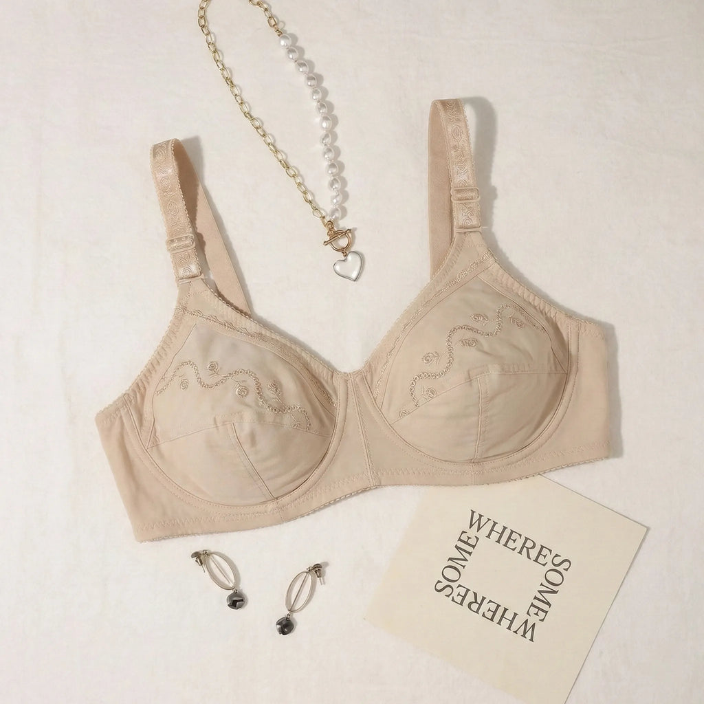 Beige bra with jewelry and a card on a light background